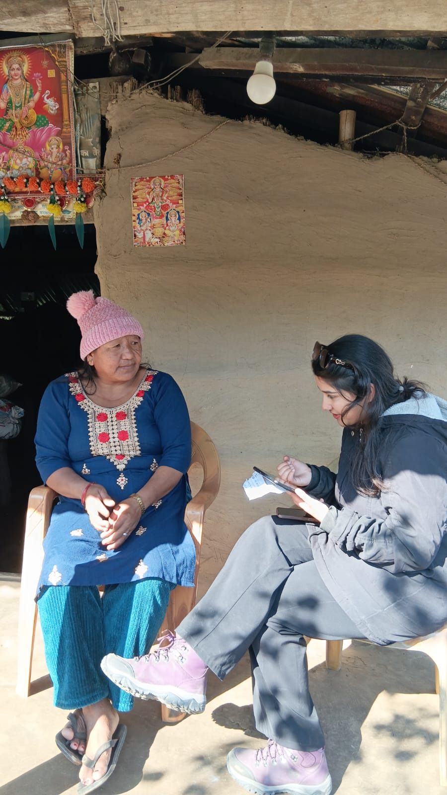 Abhishu Neupane interviewing a woman on her porch